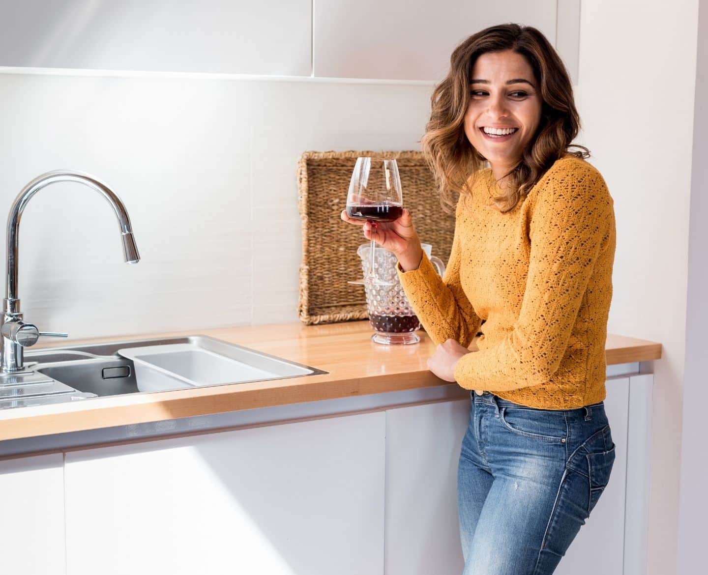 woman drinking wine at home in kitchen