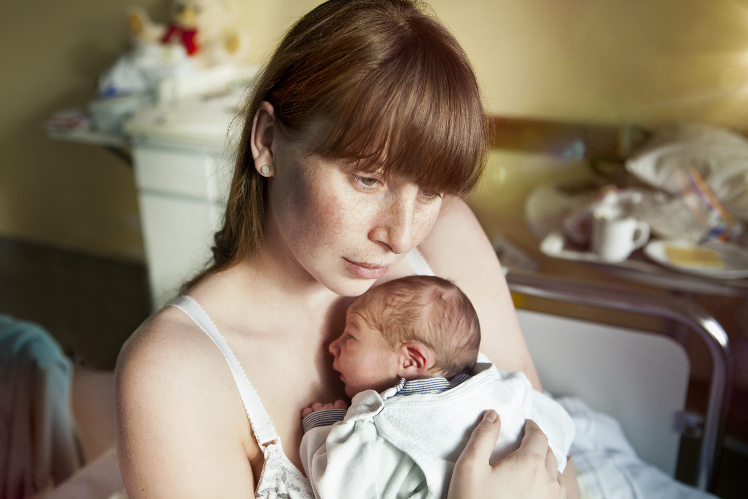 Mother holding her newborn baby in hospital room