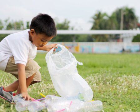 at the city public park asian child boy is a volunteer for clean up the field floor he picking up t20 0xXyVk Motherly