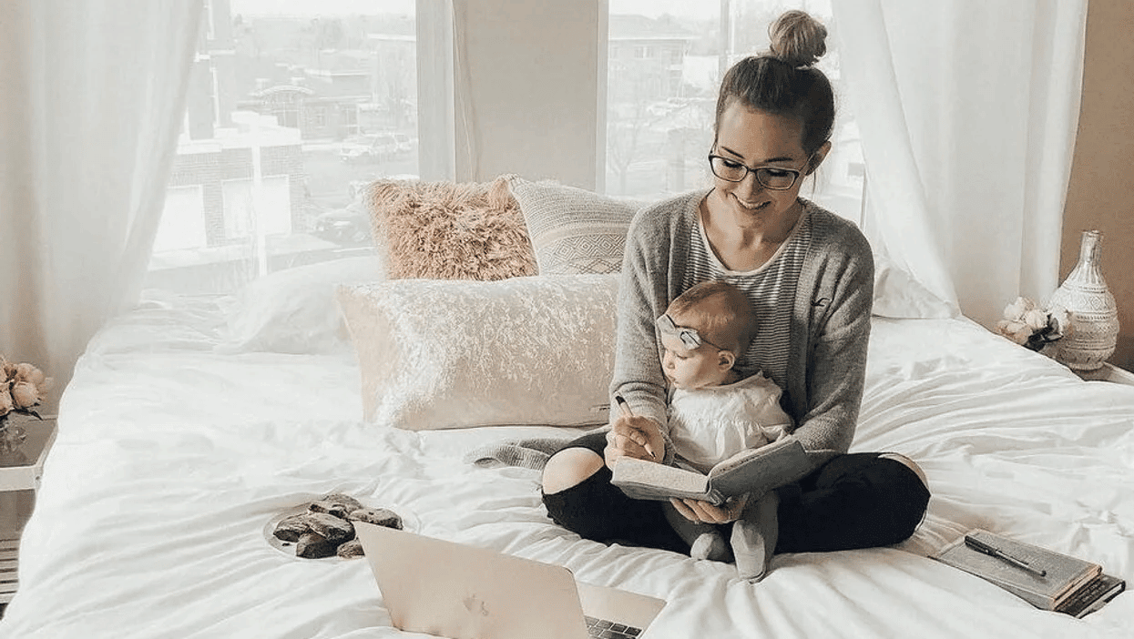woman sitting with baby at home while working - workplace flexibility
