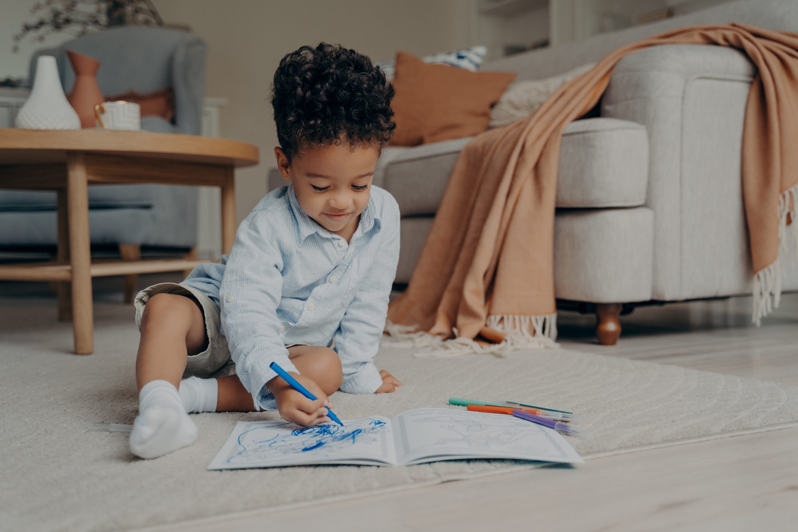 lovely african child sitting on floor at home in stylish living room with colored felt tip pens and t20 mlKaQj scaled Motherly