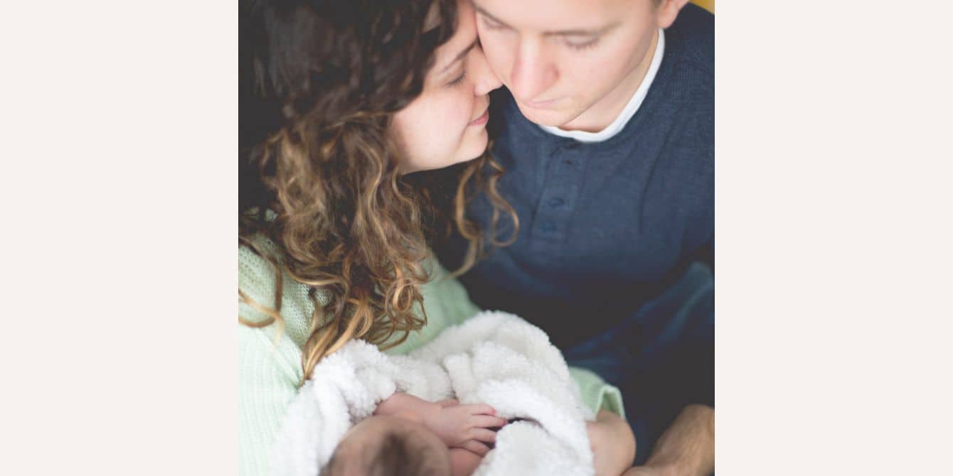 mom and dad snuggling a newborn baby - essay on pregnancy loss