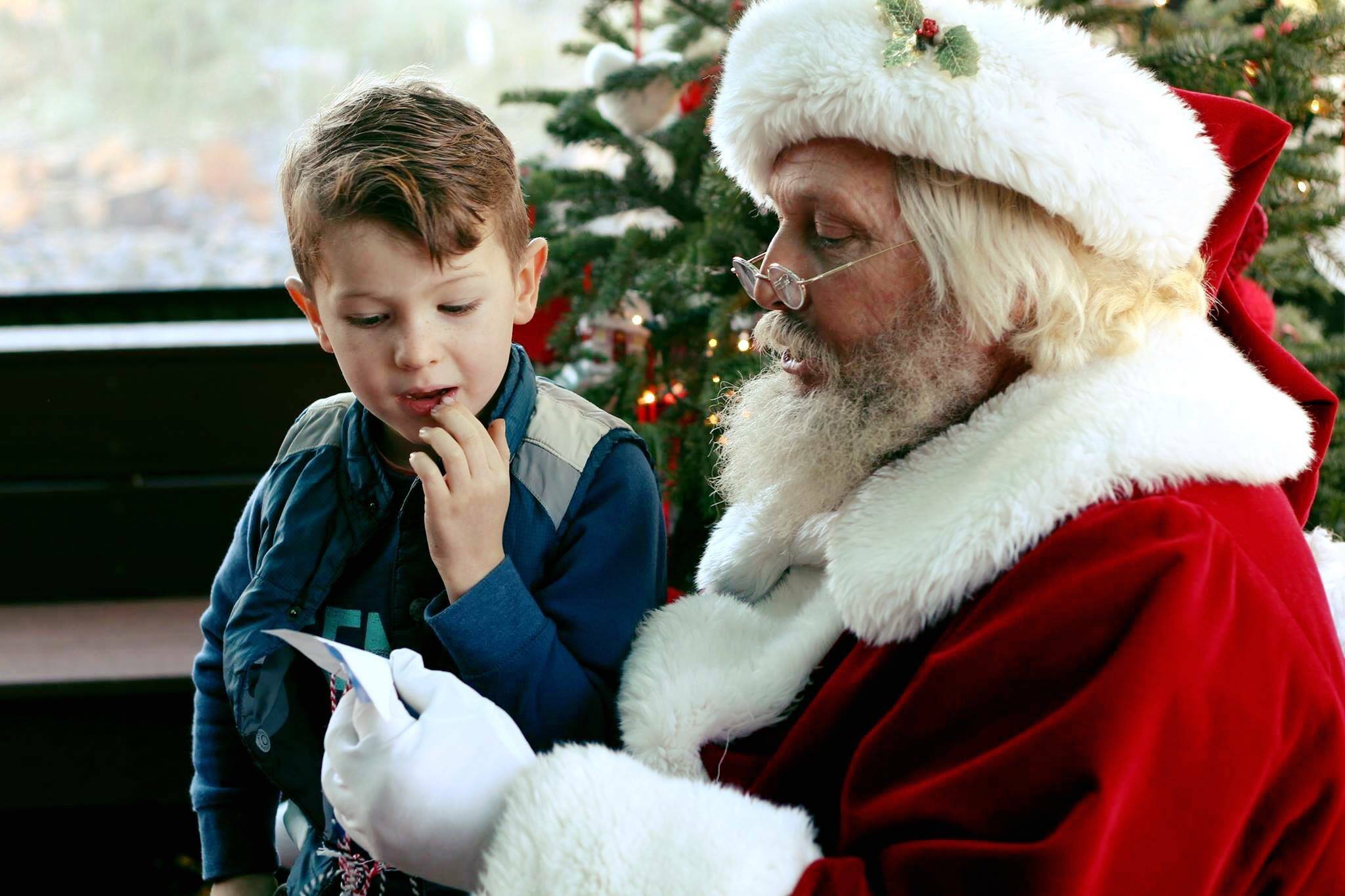 santa claus reading a child a christmas letter - how to call santa claus