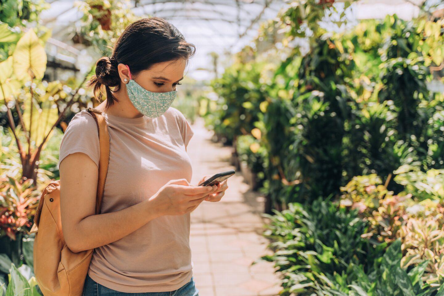 woman wearing a mask in a greenhouse