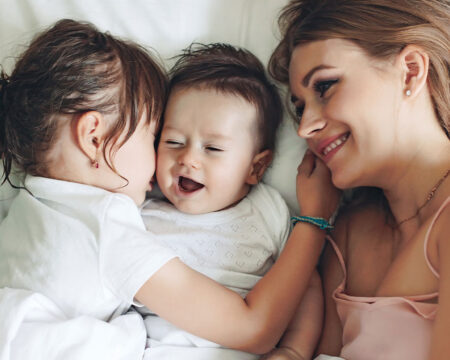 mom in bed with her five year old and baby Motherly