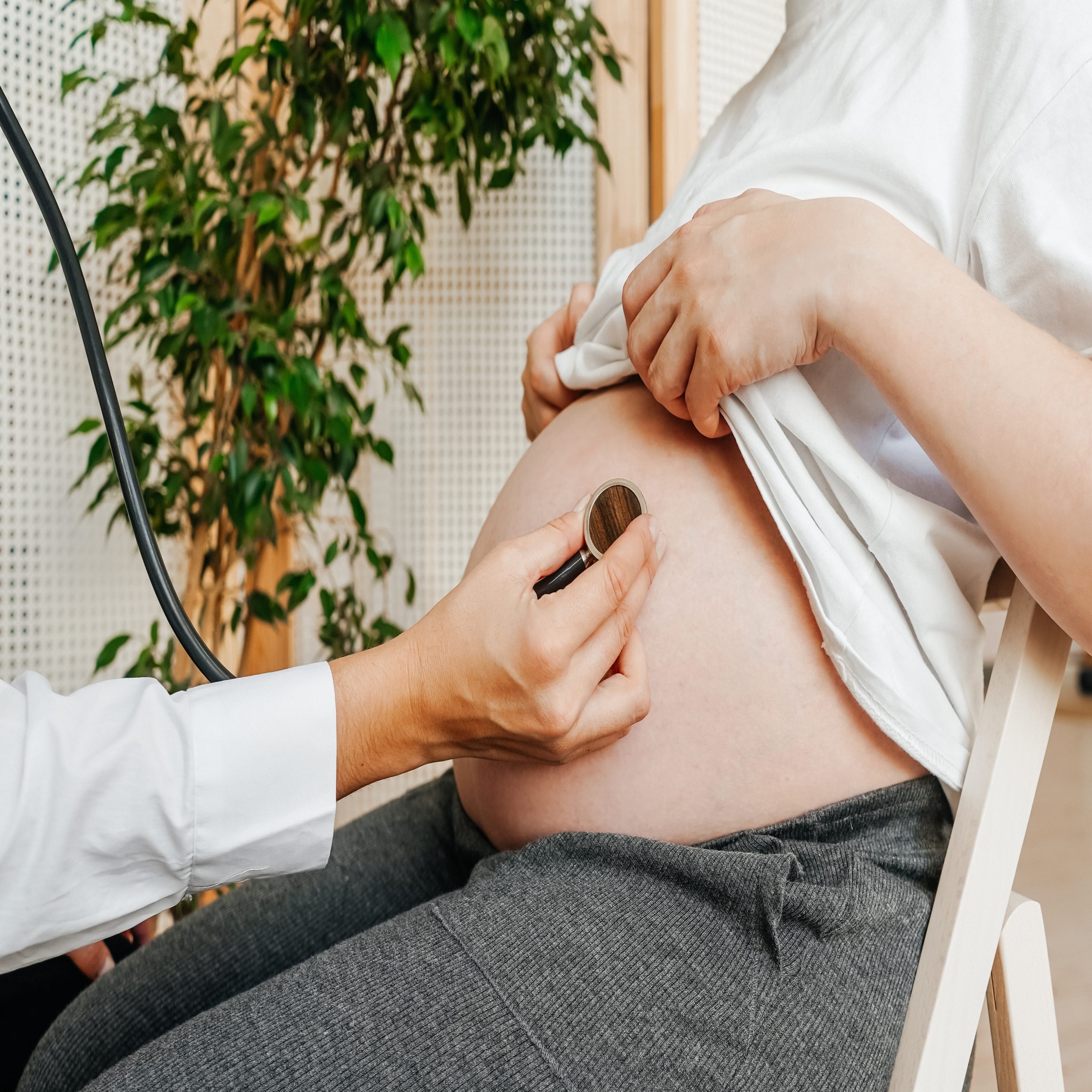 pregnant woman at the doctors appointment doctor listens to the belly with a phonendoscope t20 3dnKxo scaled Motherly
