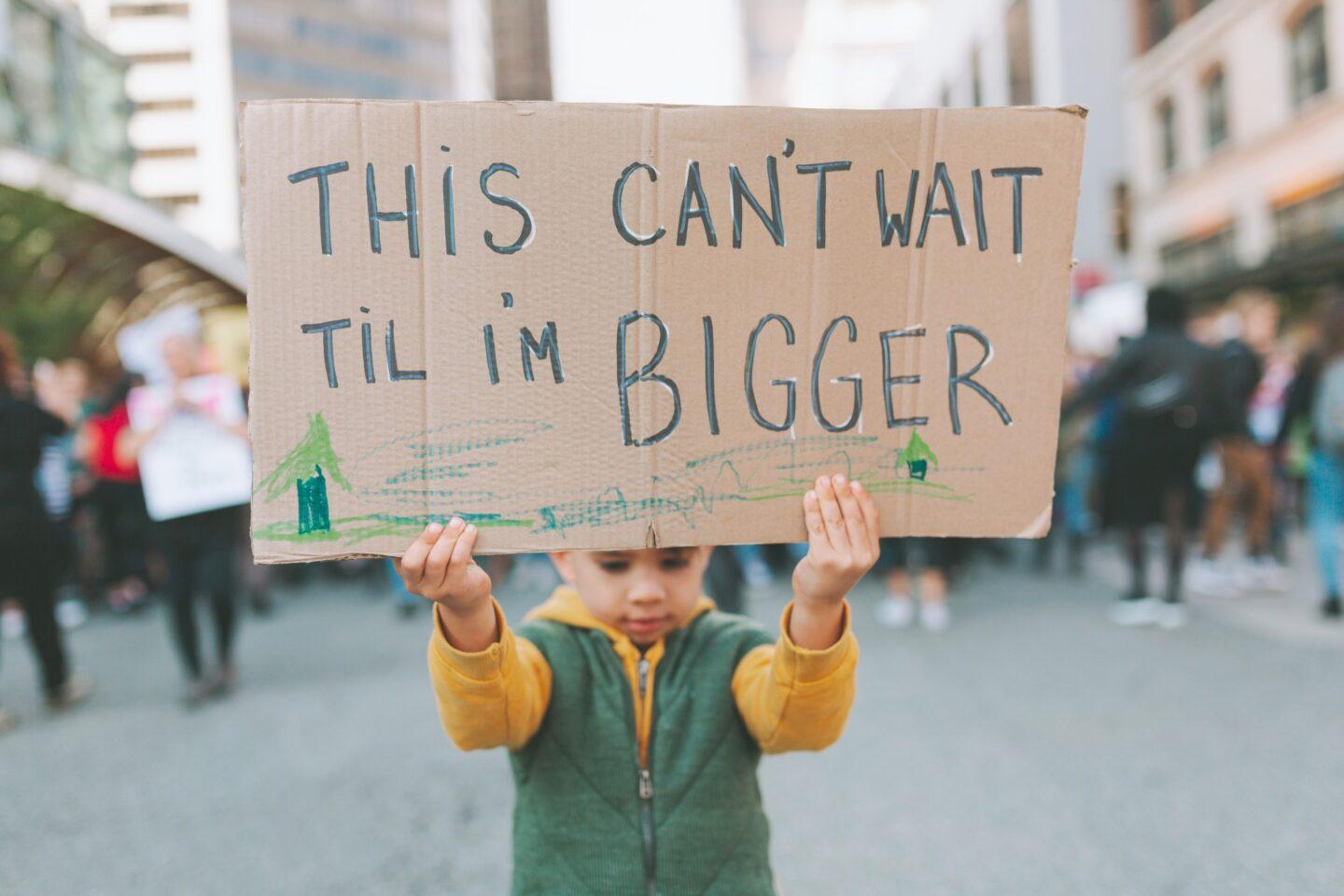 kid holding climate change sign
