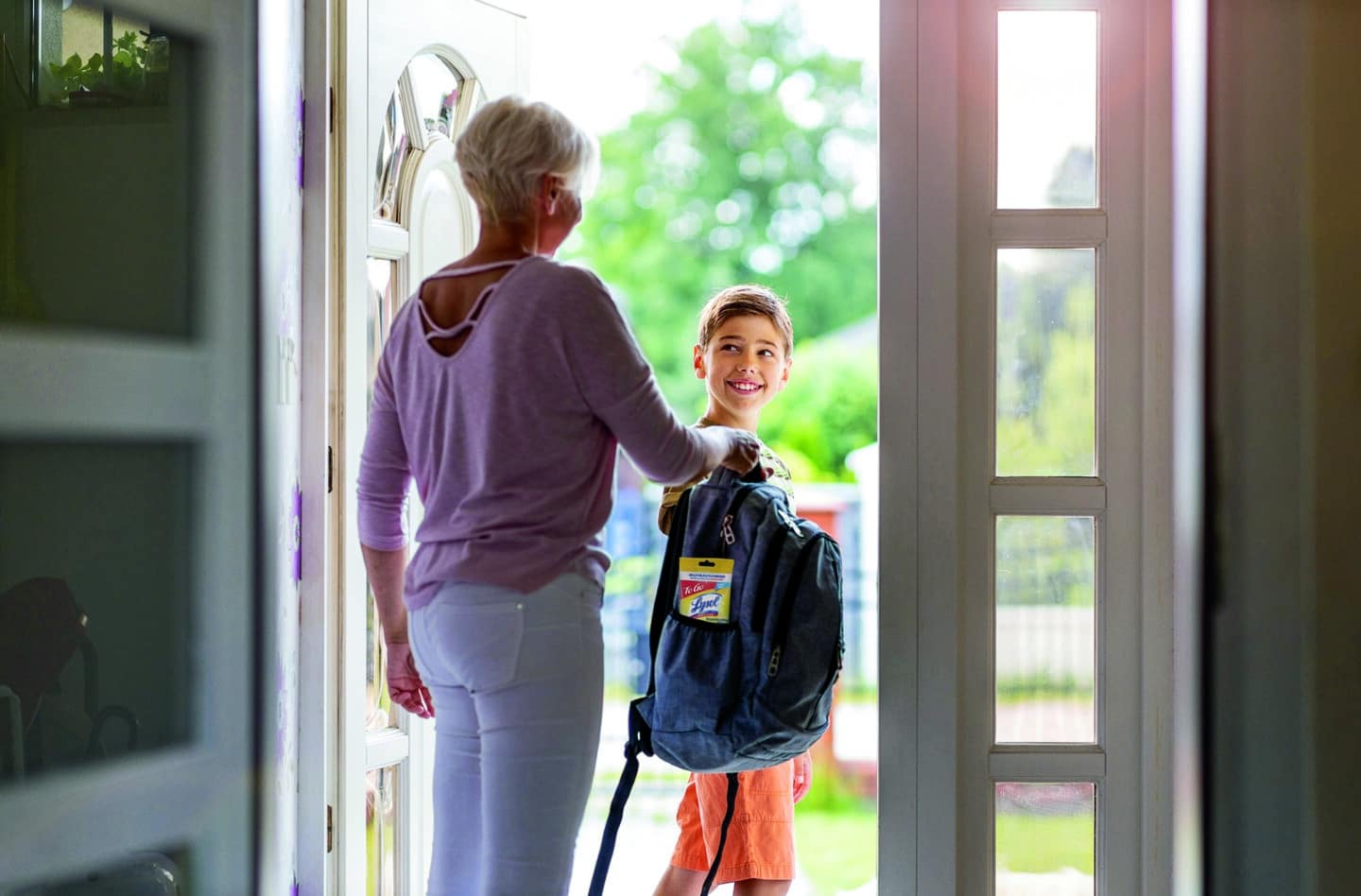 Mother and son with backpack in entrance hall