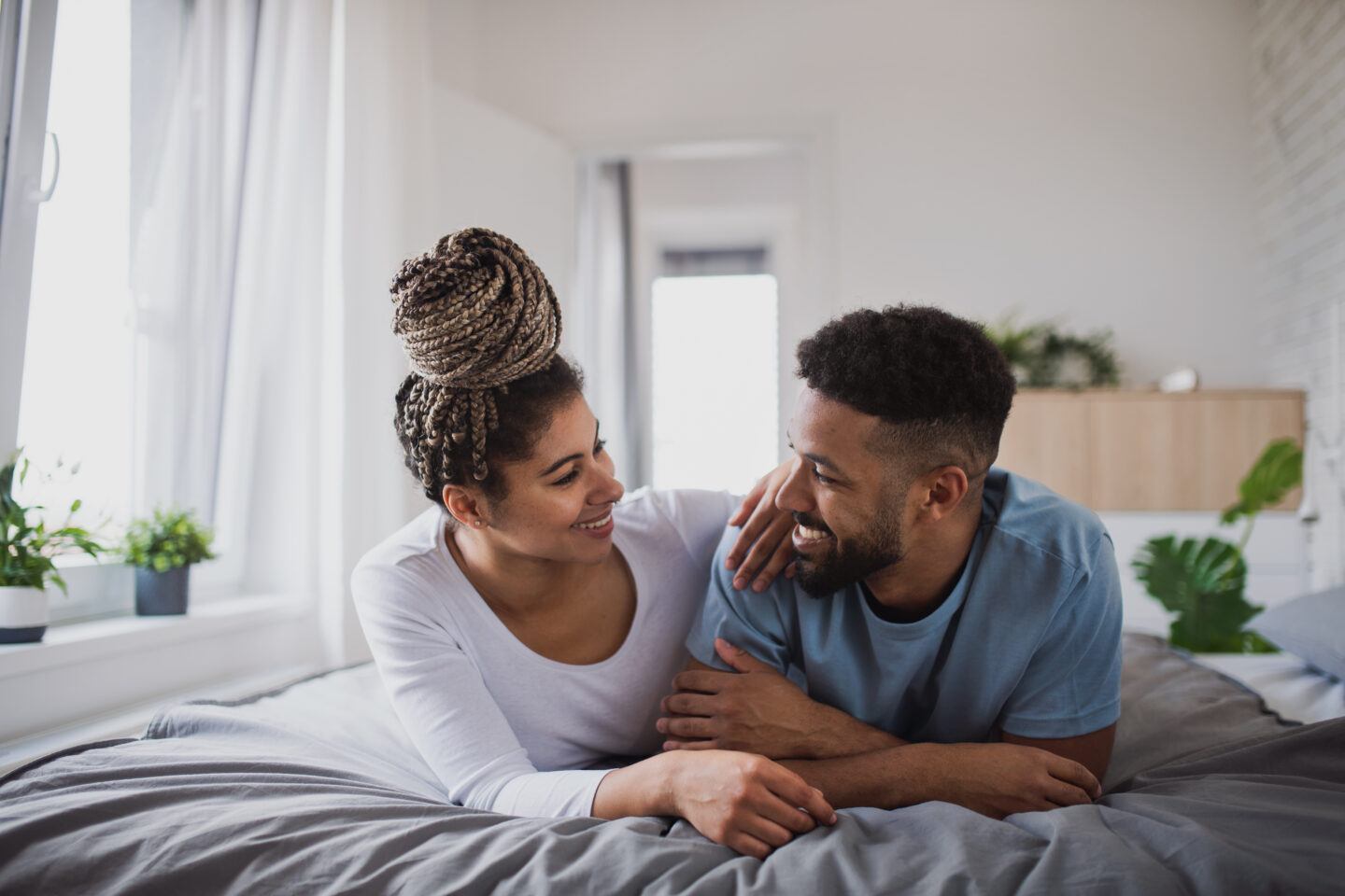 chances of getting pregnant: couple looking at each other while lying in bed