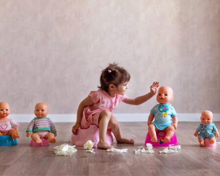 little girl potty training with her dolls