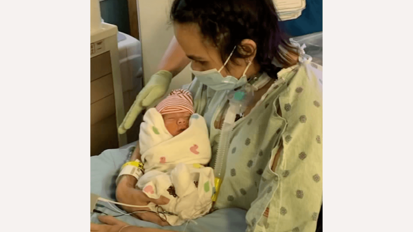 Mom holding baby after Covid, heart attack, and stroke