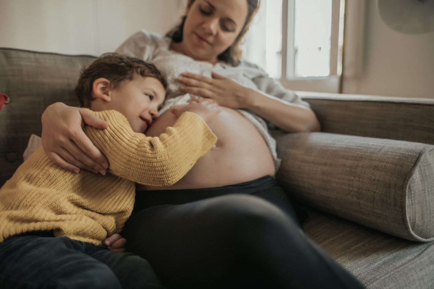 pregnancy ambivalence: boy touching his mother's pregnant belly