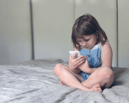 caucasian child girl preschooler immersed in the telephone digital addiction of the child the concept t20 E0RG0J