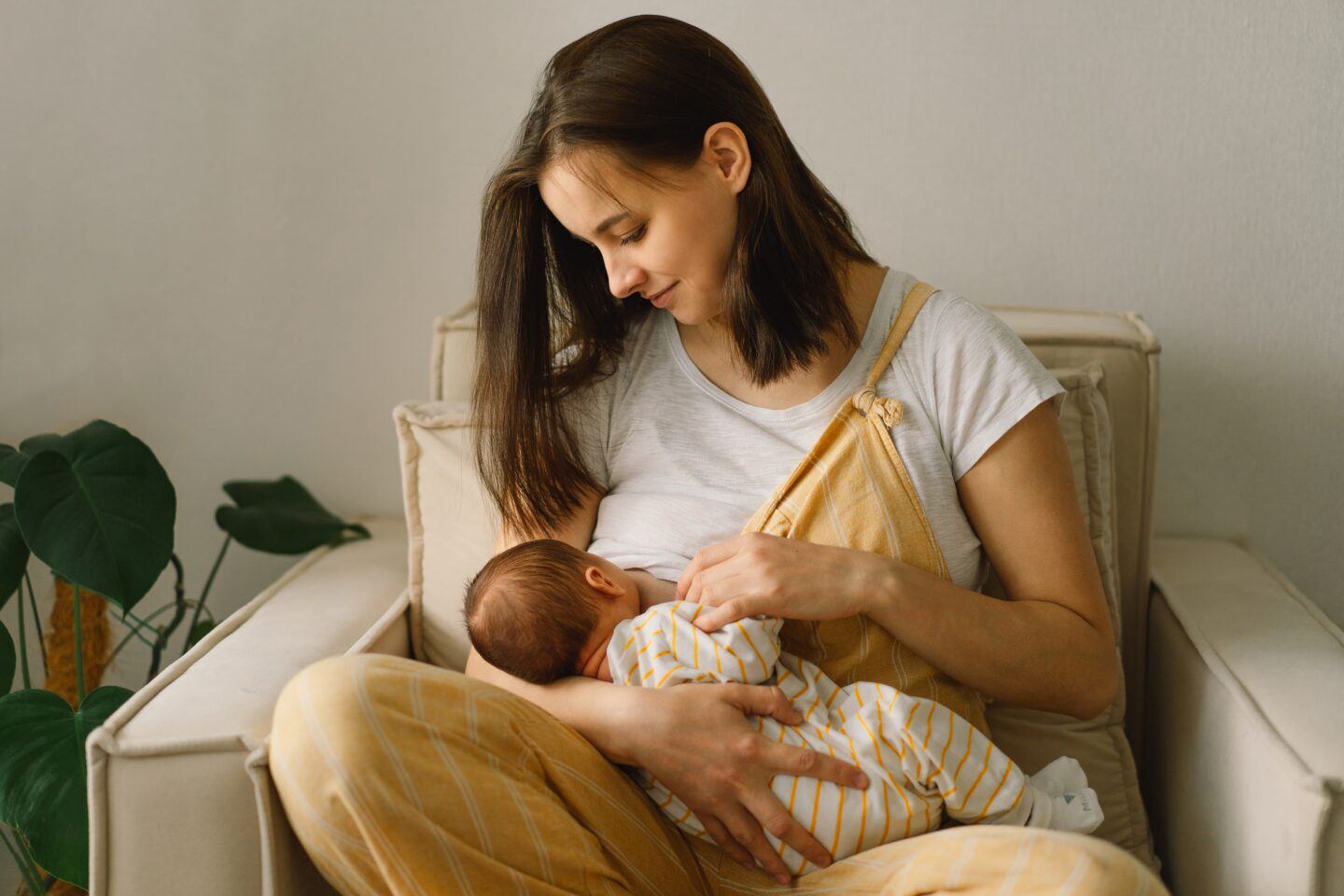 is baby getting enough milk: mother breastfeeding infant in nursery