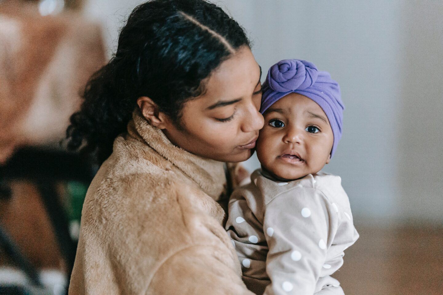 mom kissing baby on the cheek