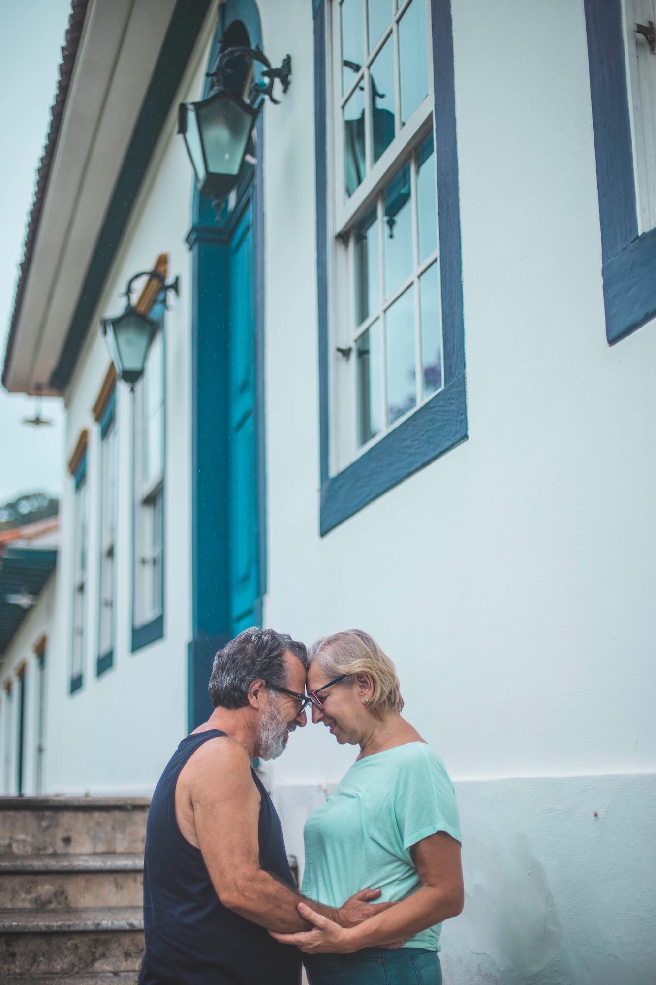 older couple standing with their heads together outside