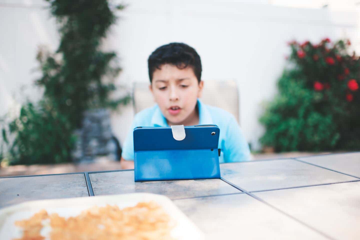 EndeavorRx: young boy playing with ipad outside