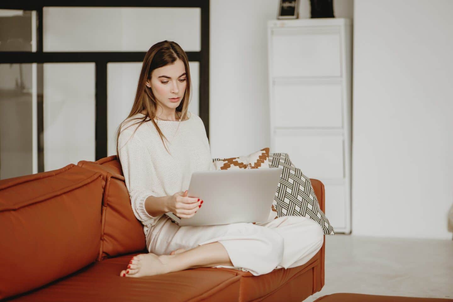 ttc support groups: woman looking at laptop at home on sofa