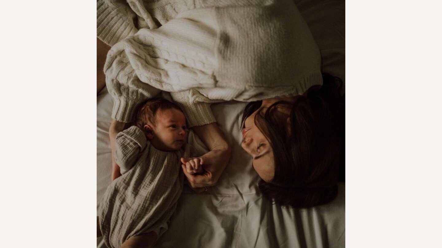 photo of mom and baby laying on a bed