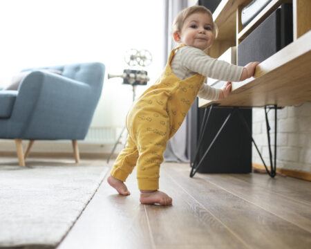 baby doesn't crawl: baby standing up and holding onto furniture
