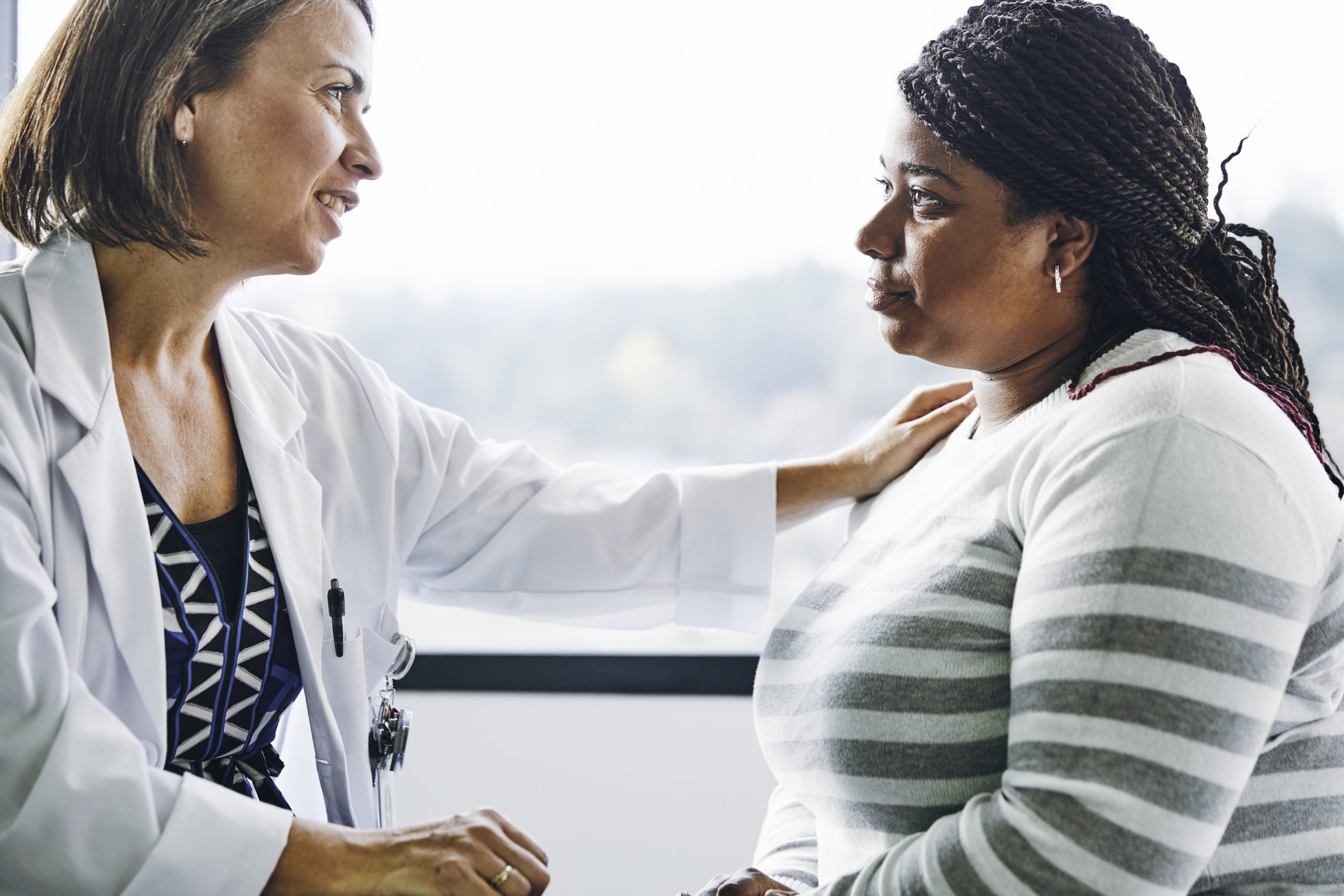 primary care: female doctor comforting female patient