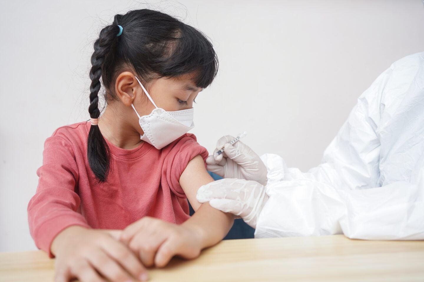 pfizer covid vaccine kids 5-11: child receiving covid vaccine in upper arm