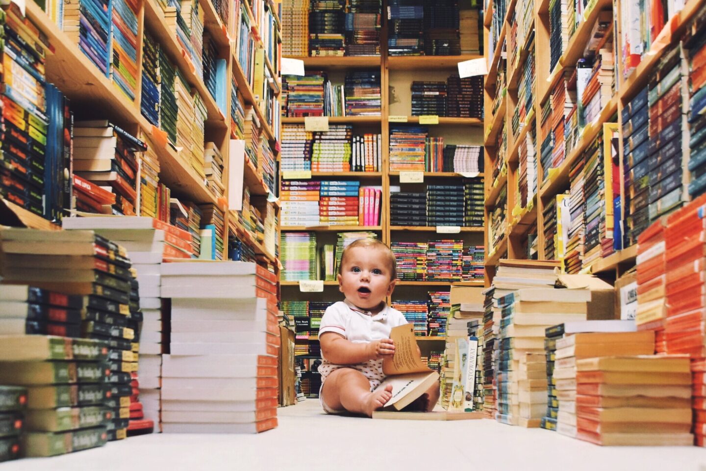 baby sitting amongst books in a library