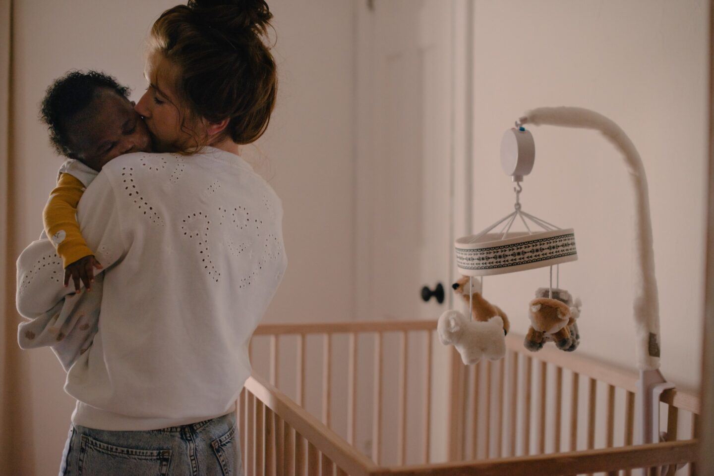 mom holding sleeping baby in a nursery