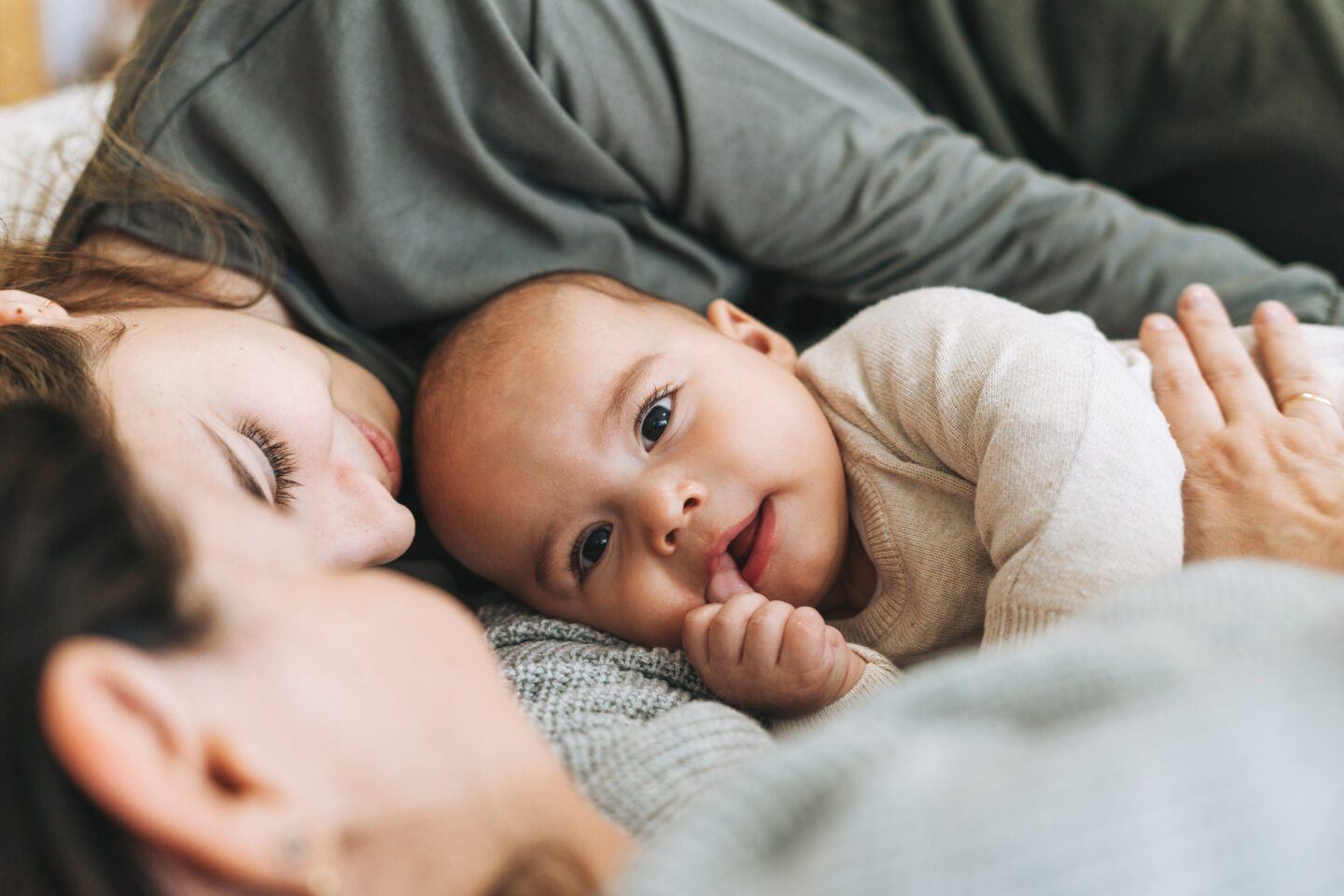 two women lying with baby