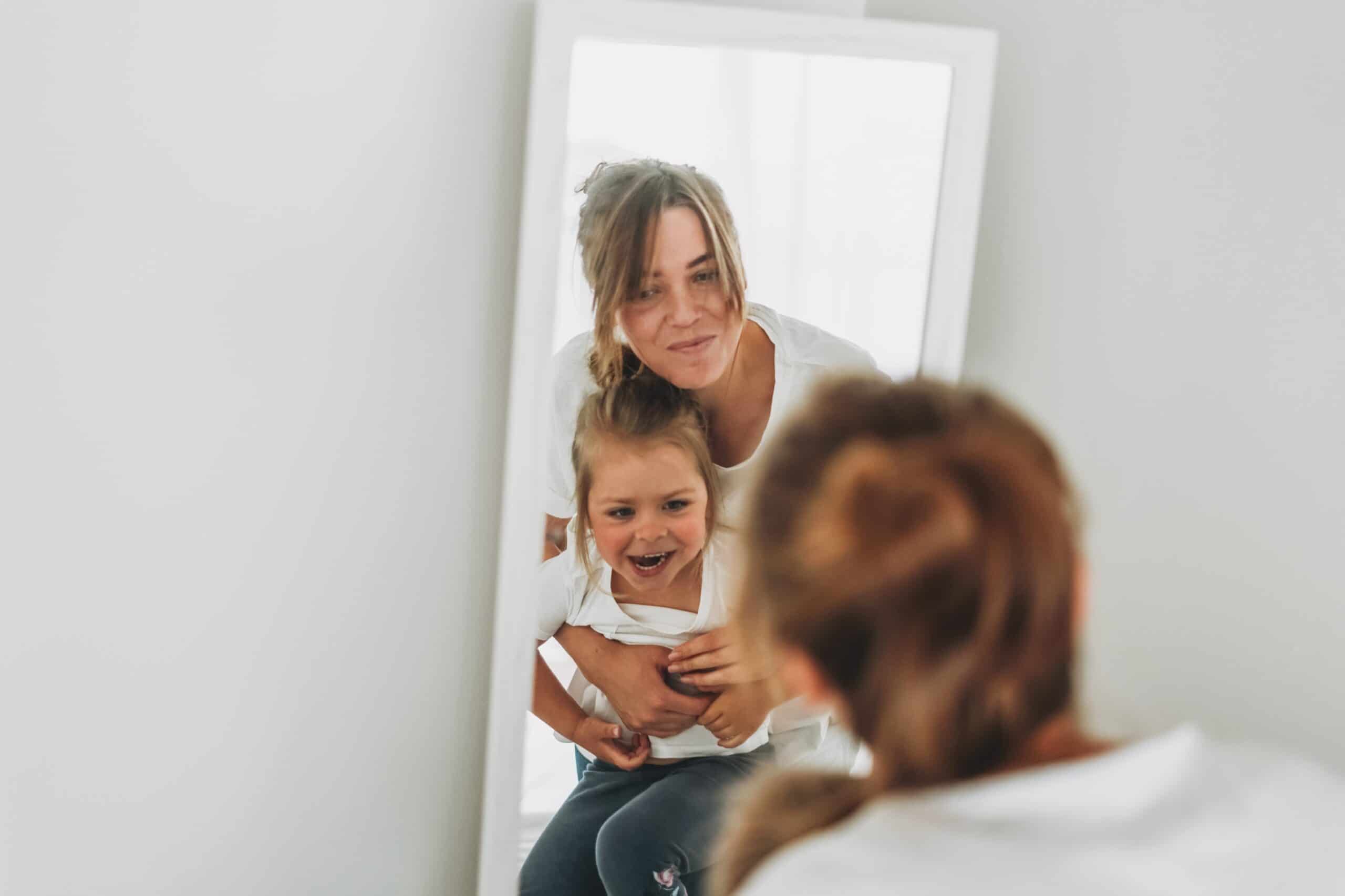 https://www.mother.ly/wp-content/uploads/2022/03/young-mother-and-daughter-in-white-t-shirts-look-in-the-mirror-family-having-fun_t20_E0Rvv4-scaled.jpg
