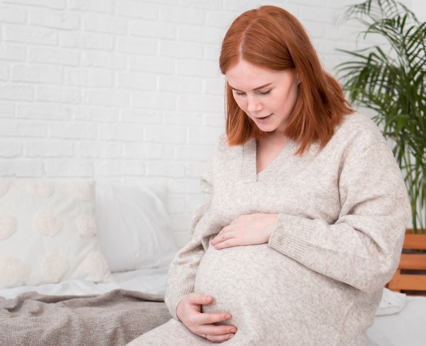 prenatal screening tests: pregnant woman at home holding belly