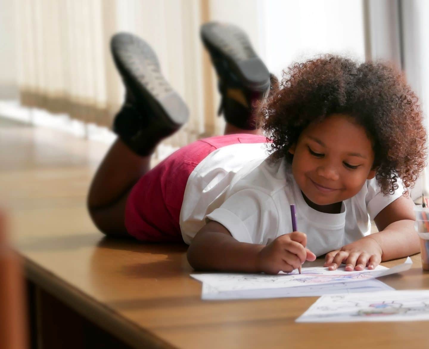 little girl coloring on the floor