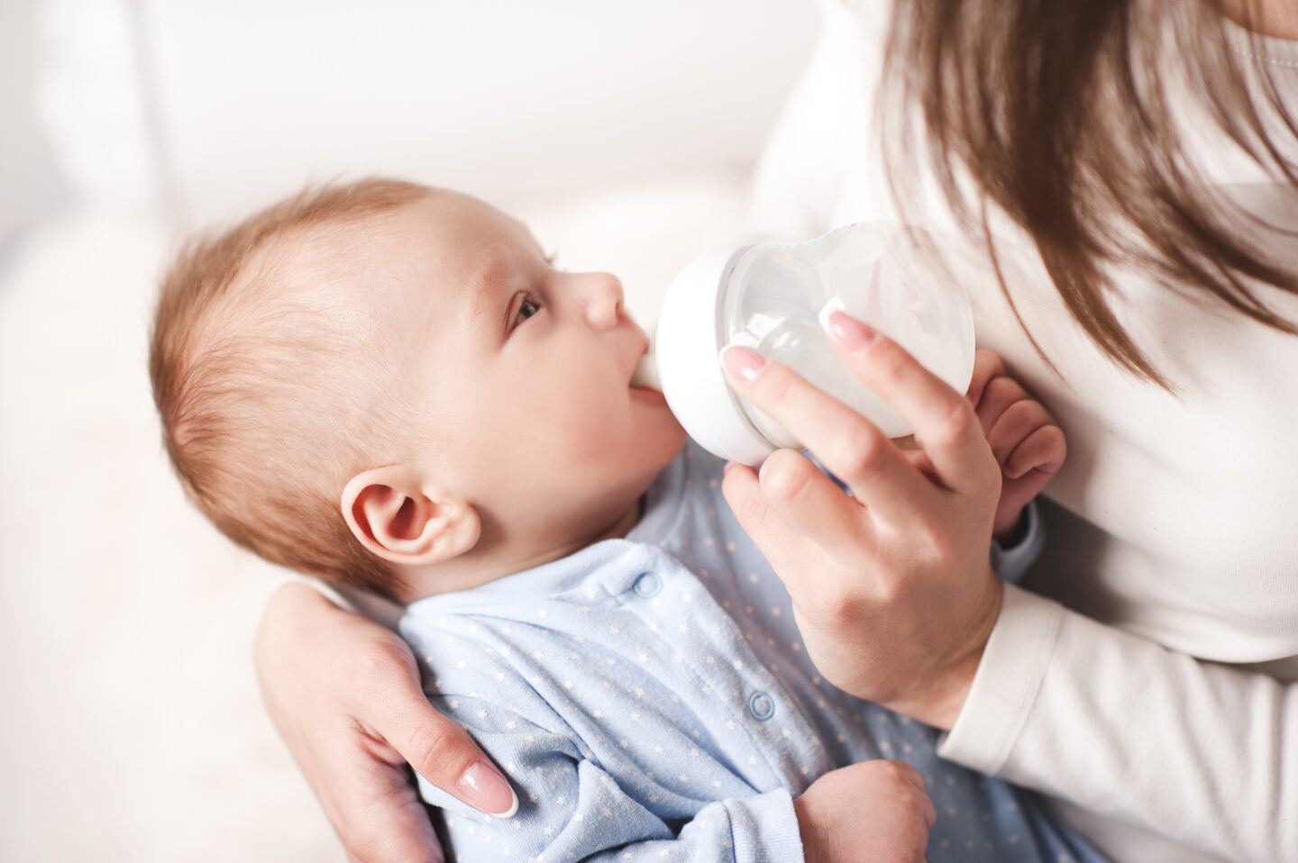 organic baby formula: mother bottle feeding baby