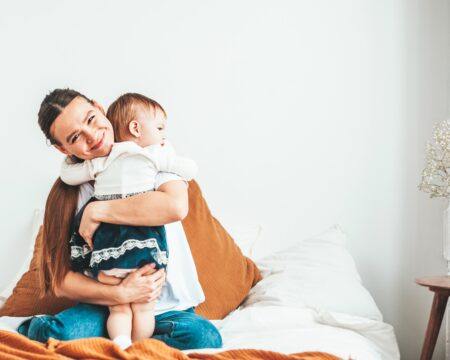 mom and baby hug on the bed at home the child snuggles up to his mother happiness to be near love and t20 O0yQO8