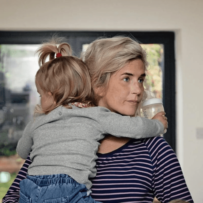 mom holding daughter on her shoulder