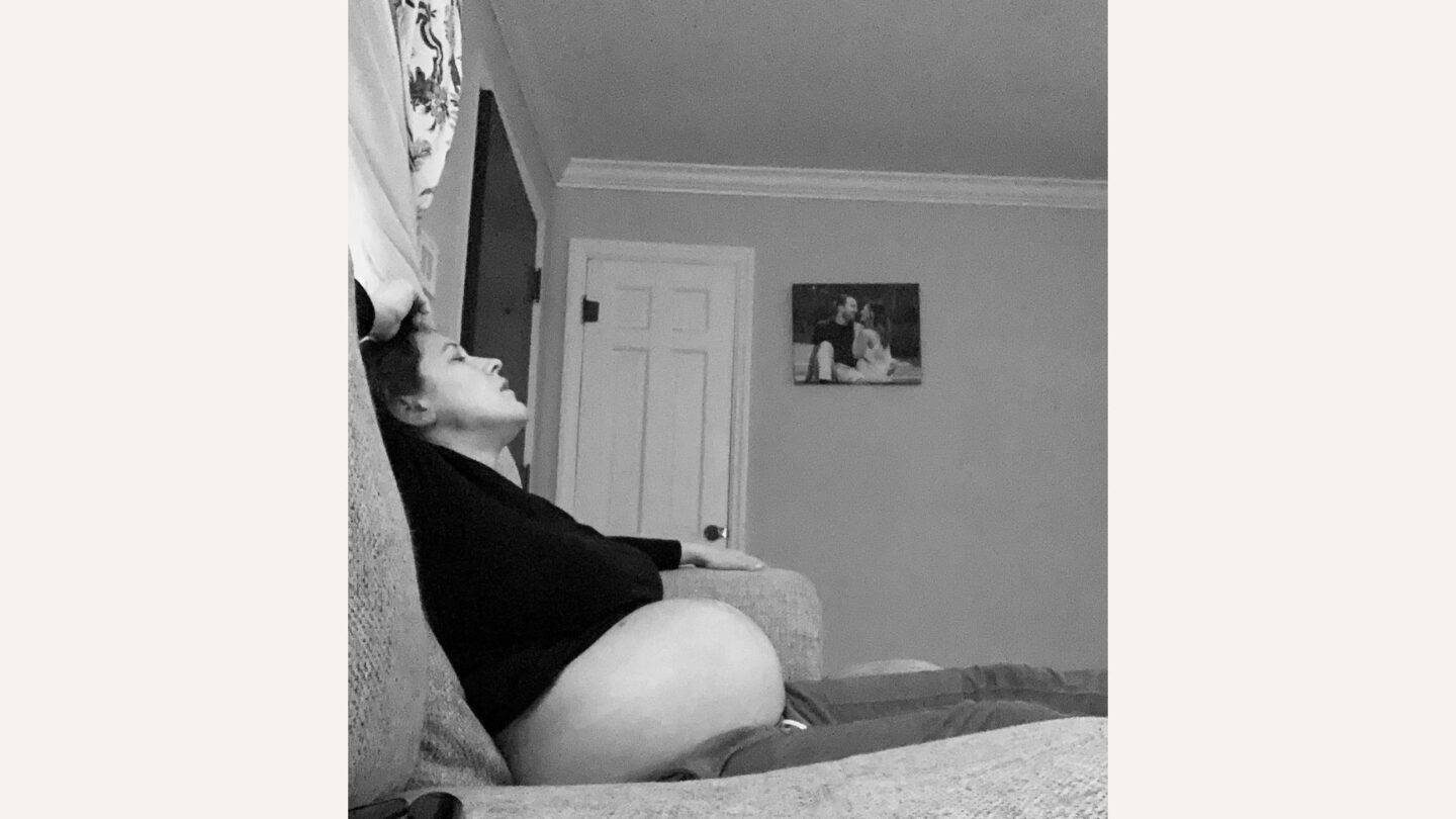 mom of two: pregnant woman sitting on couch