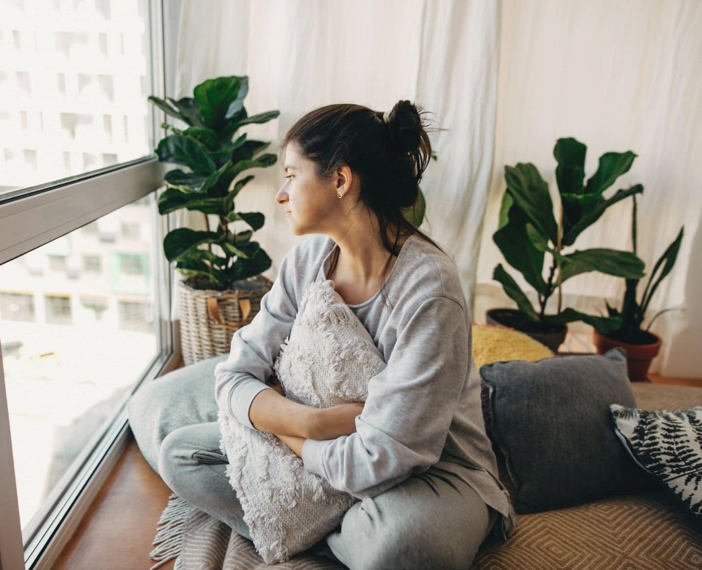 domestic violence: woman sitting alone at home looking out window