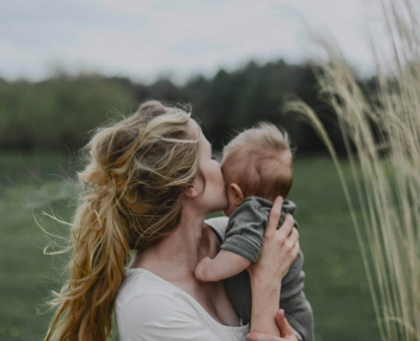 motherhood is having superpowers: mother holding and kissing baby