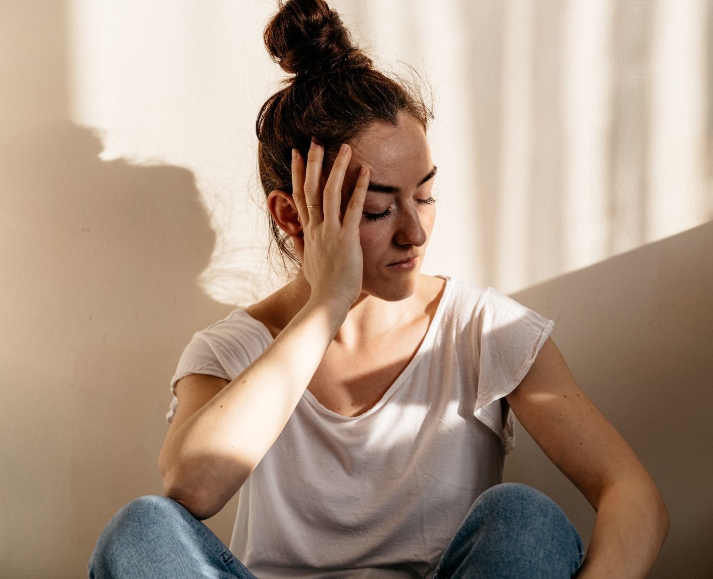 stop asking women when they're having children: sad woman sitting on floor