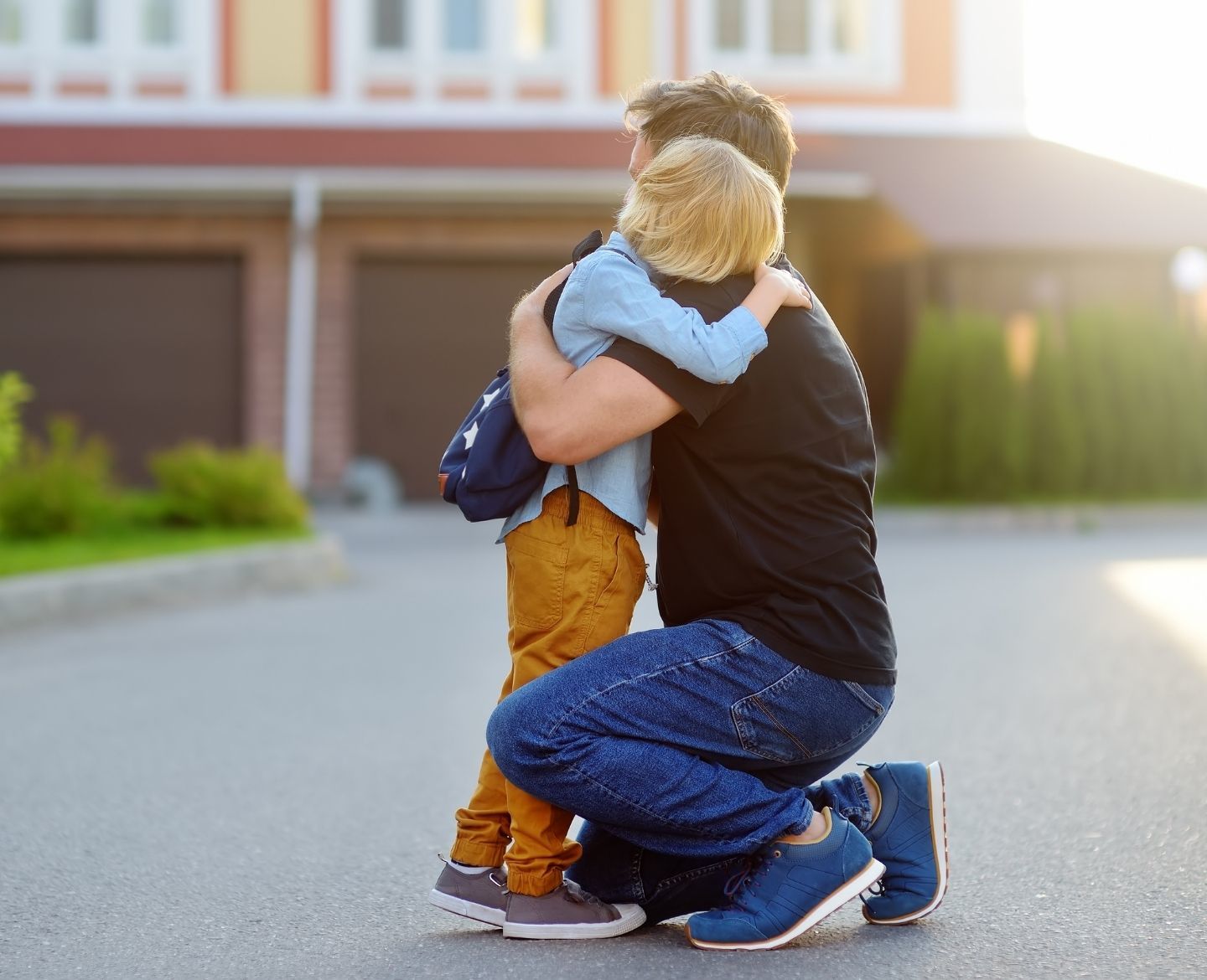 father hugging son at school