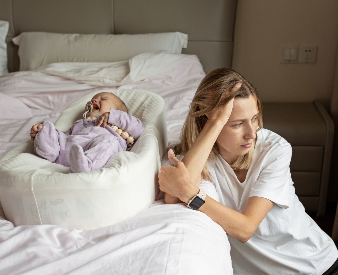 baby crying, sad mom sitting beside her