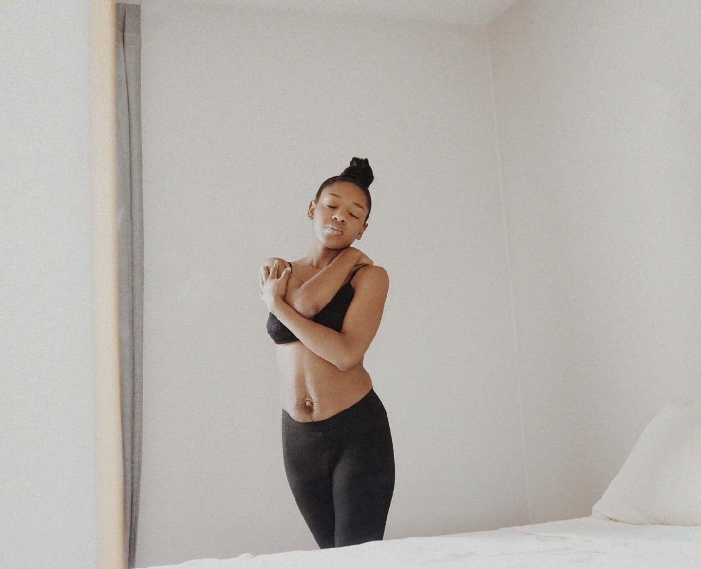 woman hugging herself showing postpartum body