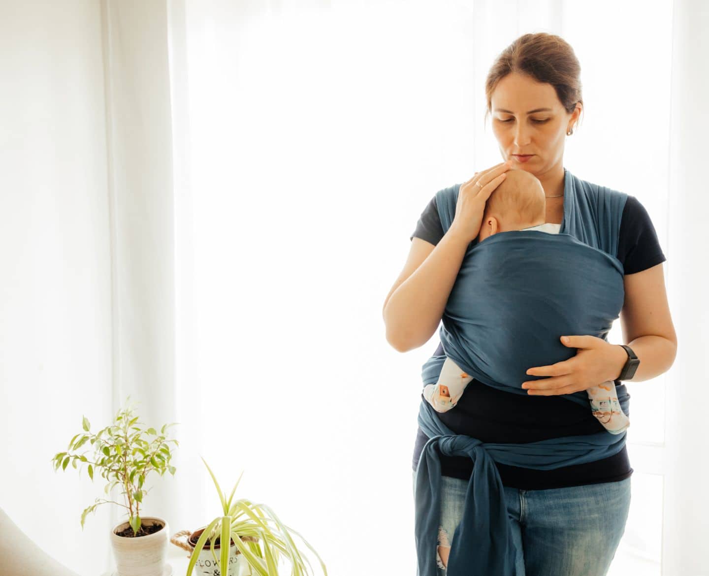 don't touch the baby: mother holding baby in baby carrier