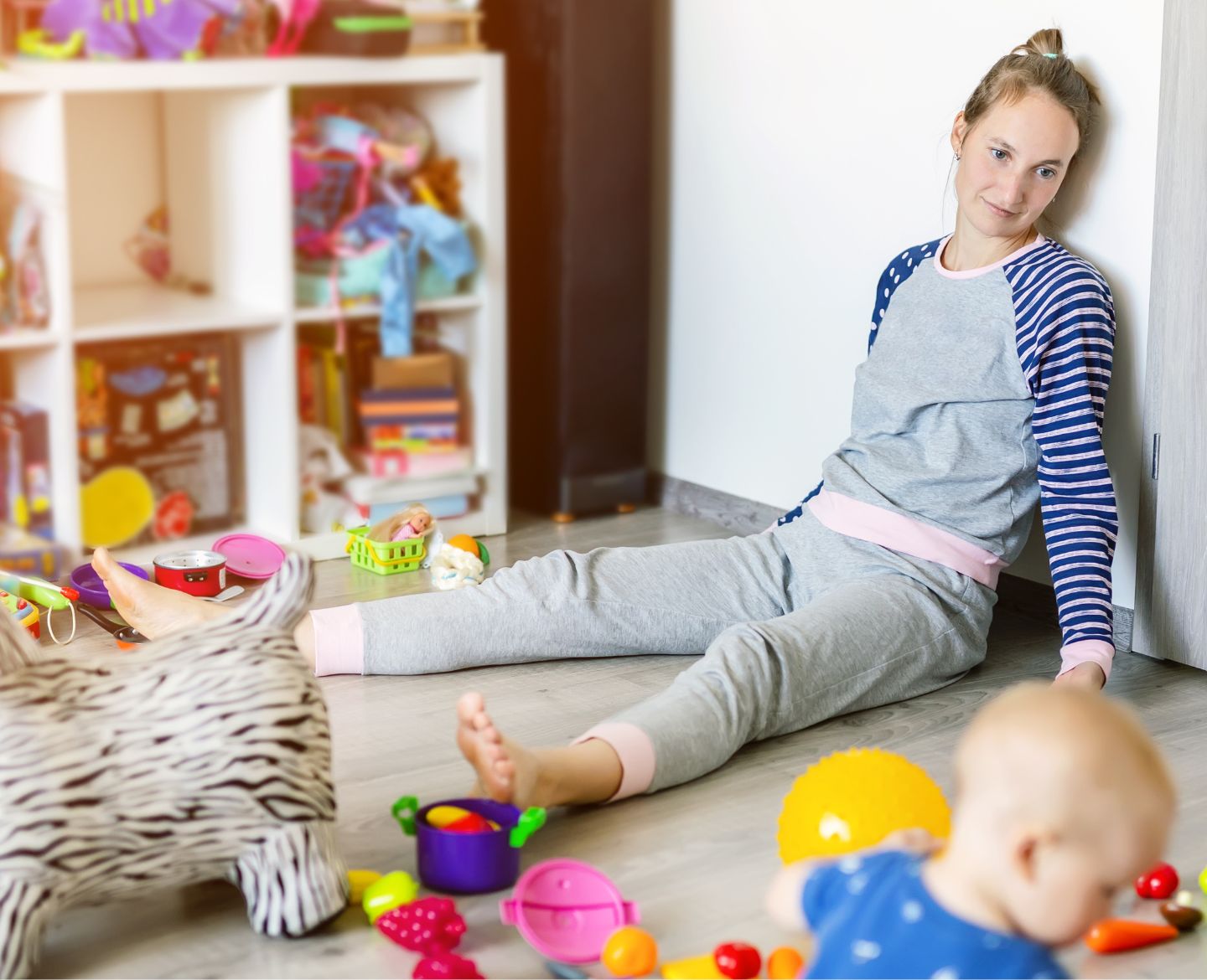 clutter: mom sitting on floor with baby surrounded by toys