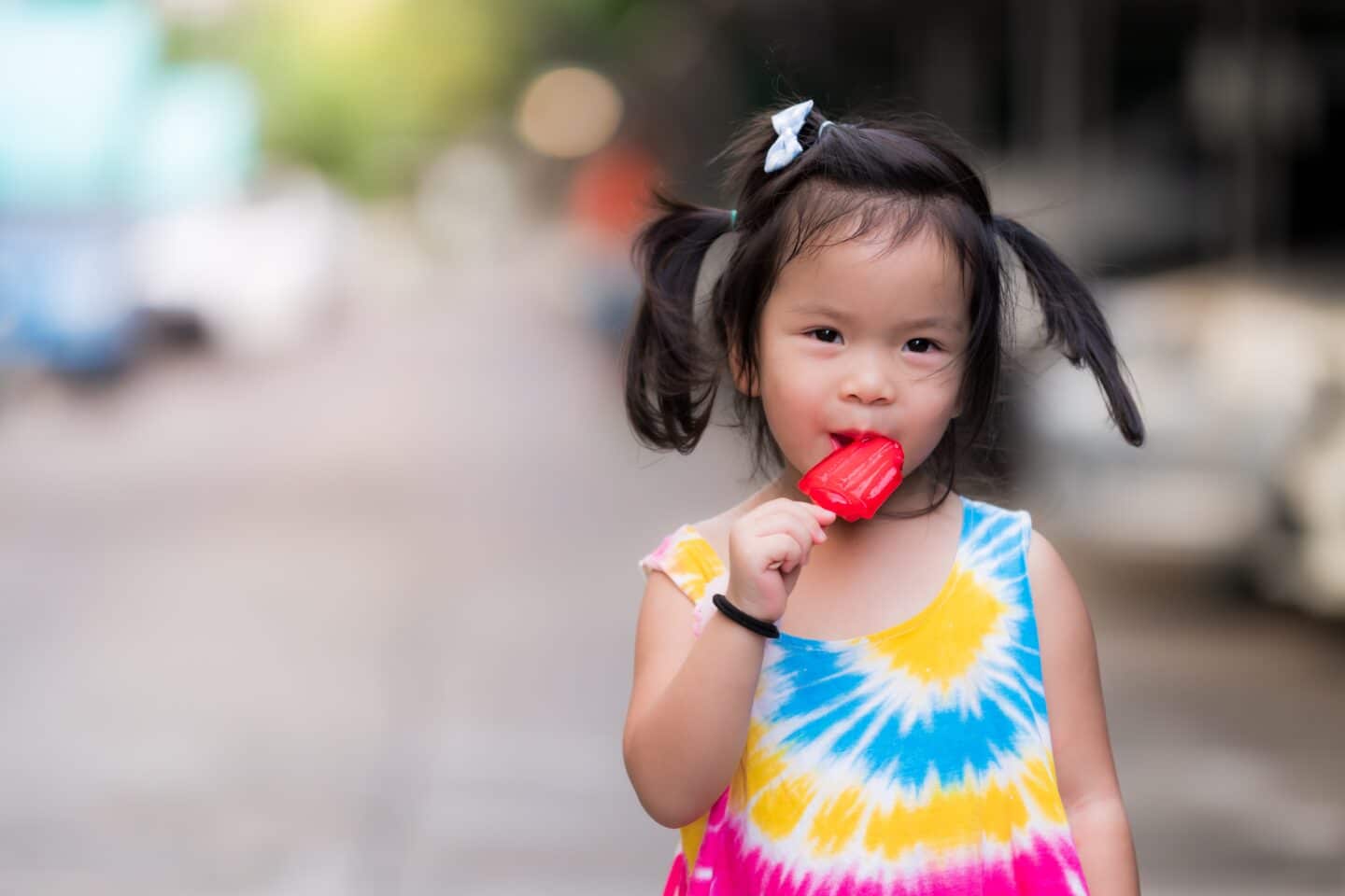 one cute little child girl eating red popsicle sticks asian children stroll in the summer evening on t20 kLLa8r Motherly