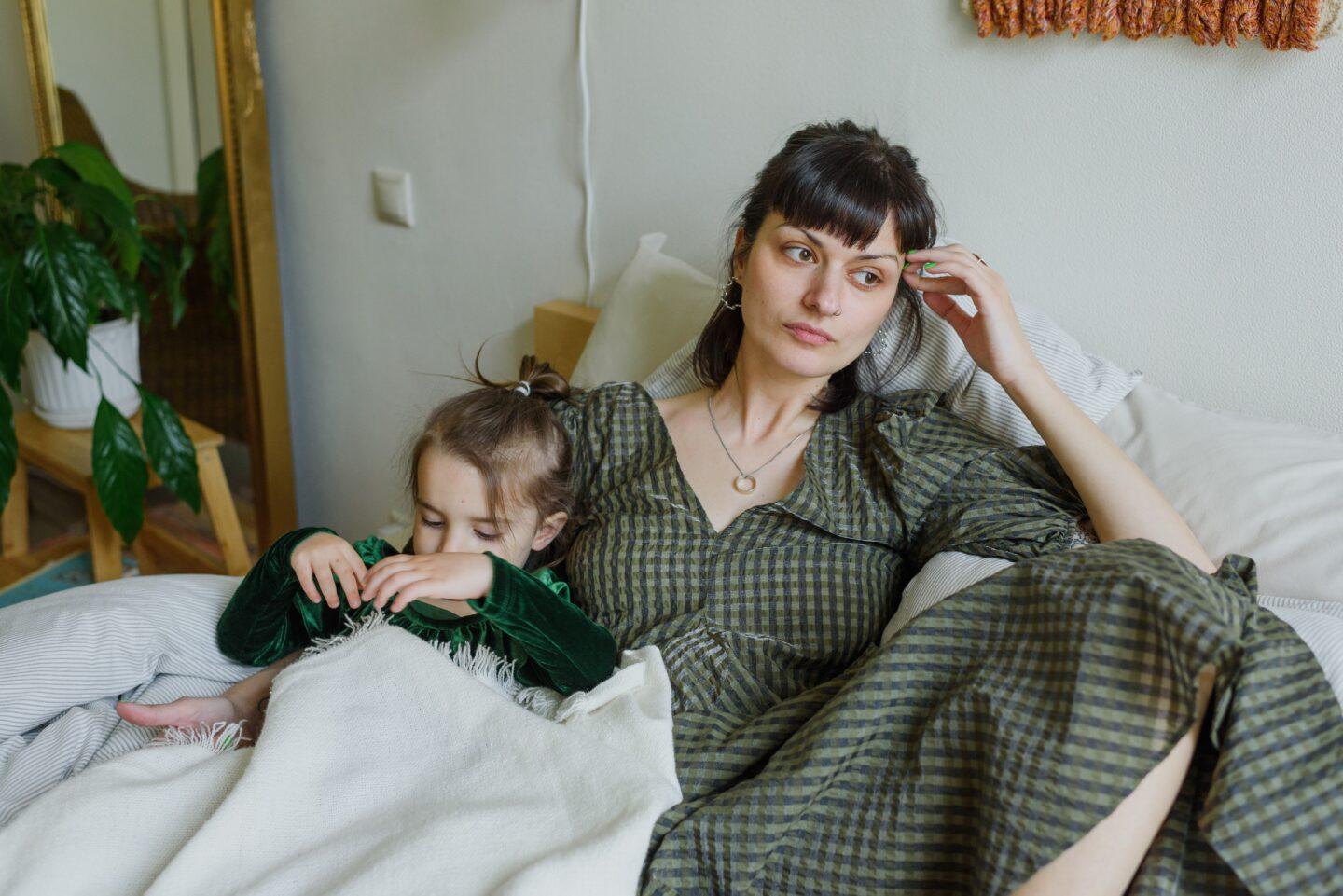 tired mother in bed with daughter