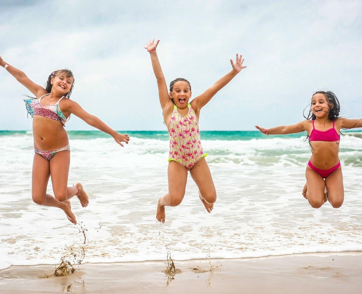 3 girls jumping on a beach