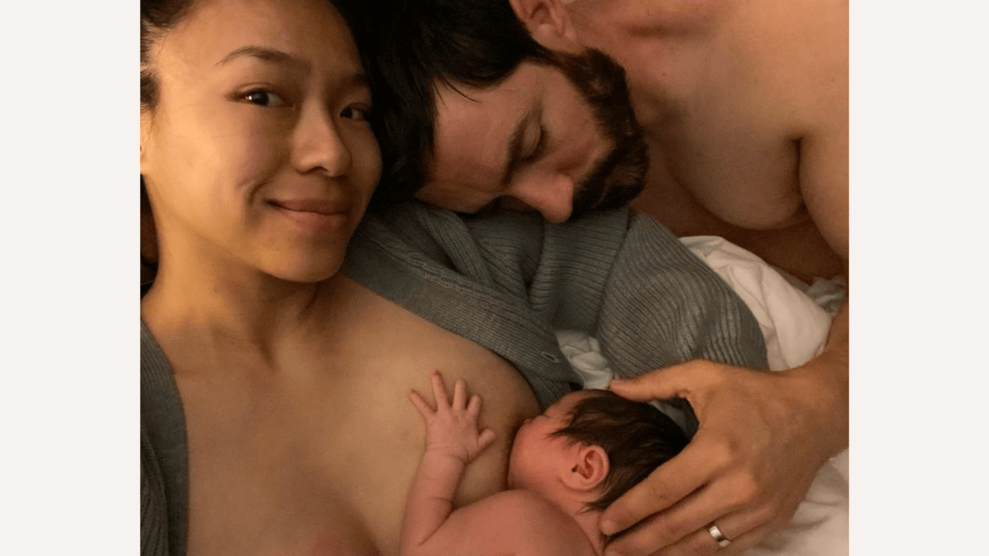 Drew Scott posing with wife and newborn