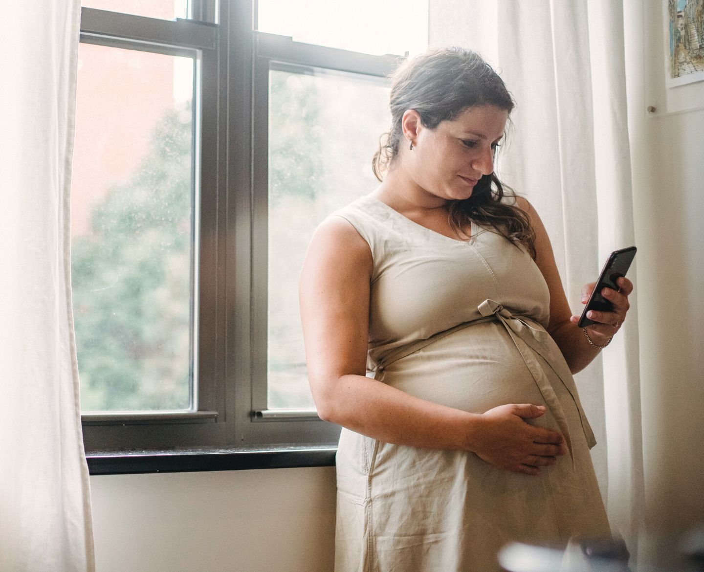 Pregnant woman texting on phone