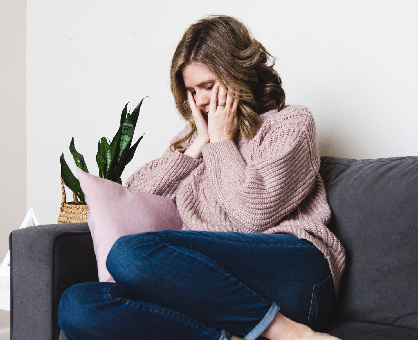 sad woman sitting on the couch - unexplained secondary infertility